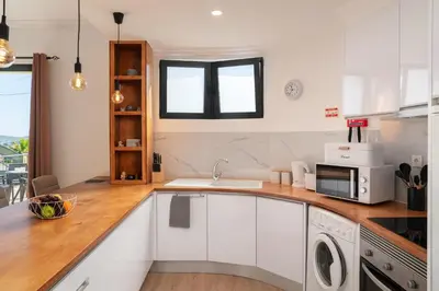 a white kitchen with a sink and a microwave at Casa Jorge Calaça by An Island Apart in Caniçal