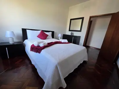 a bedroom with a large white bed with red pillows at Silva House in Ribeira Brava