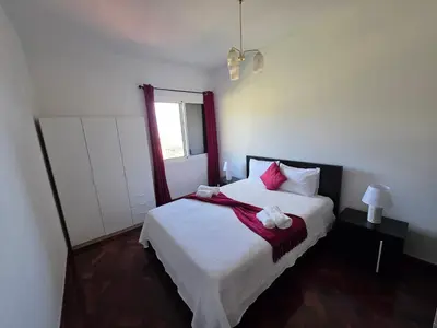 a bedroom with a large bed with pink pillows at Silva House in Ribeira Brava