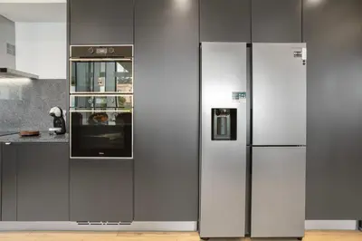 a kitchen with black cabinets and a counter with a window at Casa Jolie in Ponta do Sol