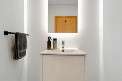 a bathroom with a white sink and a mirror at Casa Jolie in Ponta do Sol
