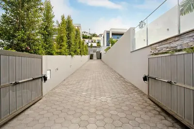 an empty driveway with two gates and trees at Casa Jolie in Ponta do Sol