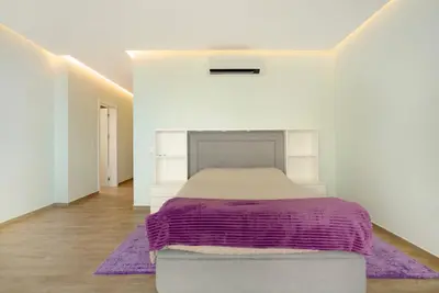 a bedroom with a bed with a purple blanket at Casa Jolie in Ponta do Sol