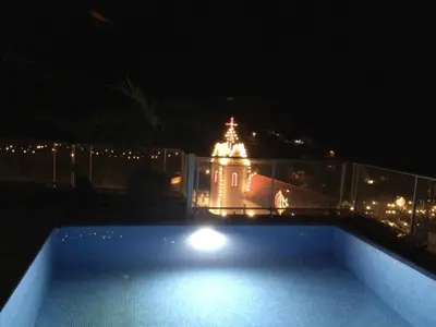 a view of a building at night with a swimming pool at Tabua Lodge in Ponta do Sol