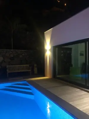 a swimming pool in front of a house at night at Tabua Lodge in Ponta do Sol