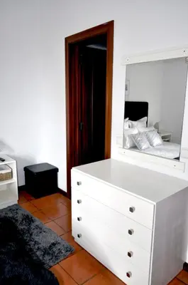 a bedroom with a white dresser and a mirror at Refúgio Guest House in São Vicente