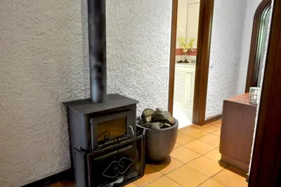 a wood stove in a room with a trash can at Refúgio Guest House in São Vicente