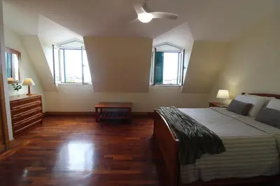 a bedroom with a large bed and two windows at Aqua City by Farmer's Market in Funchal