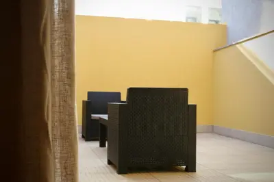 a room with two chairs and a yellow wall at Like Home III - Apartamento com 2 quartos, ideal para famílias e amigos in Funchal
