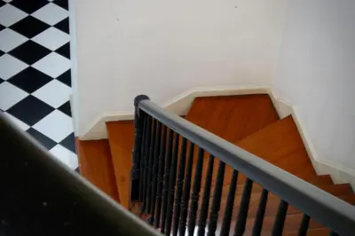 a staircase with wooden floors and a black railing at Like Home III - Apartamento com 2 quartos, ideal para famílias e amigos in Funchal