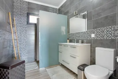a bathroom with a toilet and a sink and a mirror at Morning Glory Penthouse in Estreito da Calheta