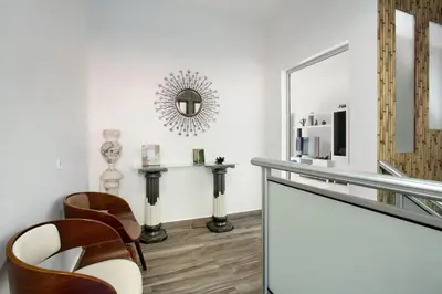 a living room with chairs and a mirror at Morning Glory Penthouse in Estreito da Calheta