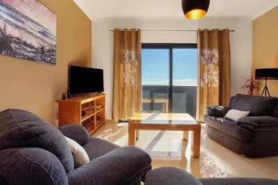 a living room with a couch and a tv at Morning Glory 2 Bedroom Apartment in Calheta