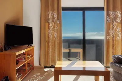 a living room with a tv and a large window at Morning Glory 2 Bedroom Apartment in Calheta