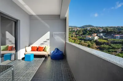 a balcony with a couch and a view of a city at Morning Glory 2 Bedroom Apartment in Calheta