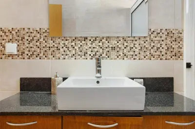 a bathroom with a white sink and a mirror at Morning Glory 2 Bedroom Apartment in Calheta