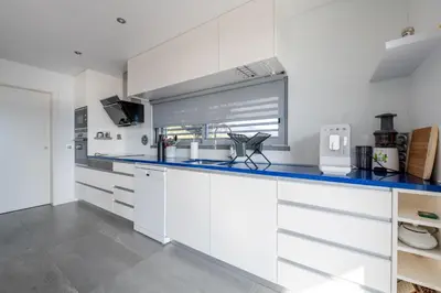 a kitchen with white cabinets and a blue counter top at The View residence in Funchal