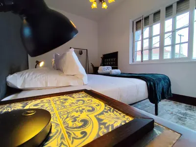 a bedroom with two beds and a table with a lamp at Francisco's in Funchal
