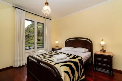 a bedroom with a large bed and a window at Bela Vale Nº4 in Ribeira Brava