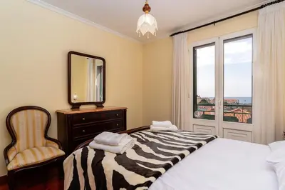 a bedroom with a bed and a mirror and a chair at Bela Vale Nº4 in Ribeira Brava