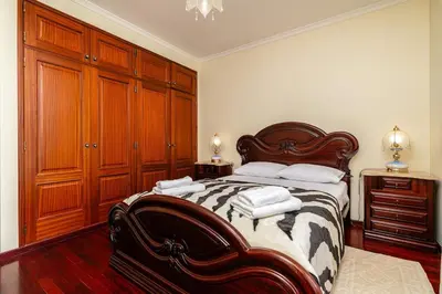 a bedroom with a bed with wooden cabinets and towels at Bela Vale Nº4 in Ribeira Brava