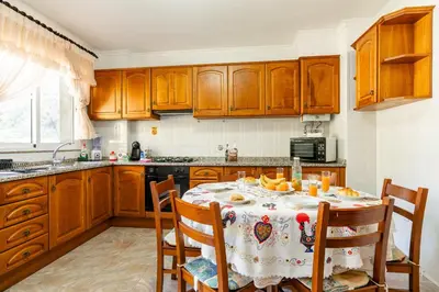 a kitchen with wooden cabinets and a table with fruit on it at Bela Vale Nº4 in Ribeira Brava