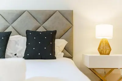 a bedroom with a bed with a headboard and a lamp at GuestReady - Ocean-View Retreat in Caniço in Caniço
