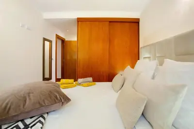 a bedroom with a large white bed with pillows at Imperatriz Madeira Apartment in Funchal