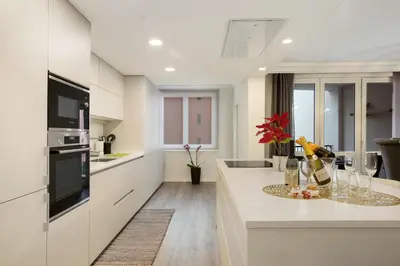 a kitchen with white cabinets and a counter top at Imperatriz Madeira Apartment in Funchal