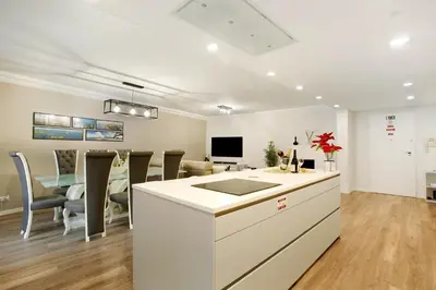 a kitchen and living room with a table and chairs at Imperatriz Madeira Apartment in Funchal