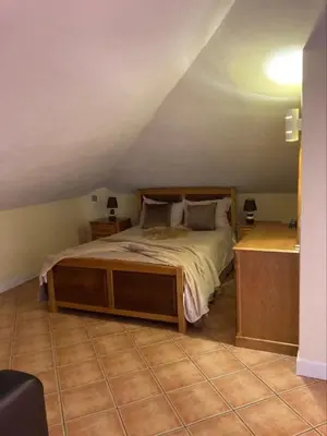 a bedroom with a large bed with a wooden frame at Casa Rosa in Ponta do Sol