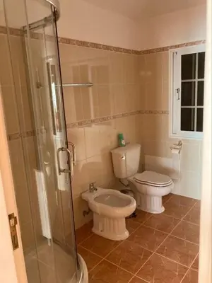 a bathroom with a toilet and a glass shower at Casa Rosa in Ponta do Sol
