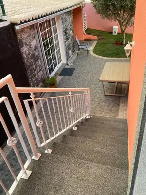 a balcony with a bench and a table on a house at Casa Rosa in Ponta do Sol