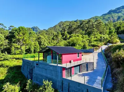 a house with a black roof on top of a building at Ginjas Mountain Houses in São Vicente