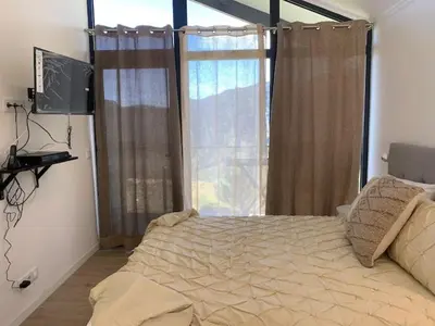 a bedroom with a bed and a large window at Ginjas Mountain Houses in São Vicente