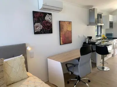 a kitchen with a desk and chairs in a room at Ginjas Mountain Houses in São Vicente