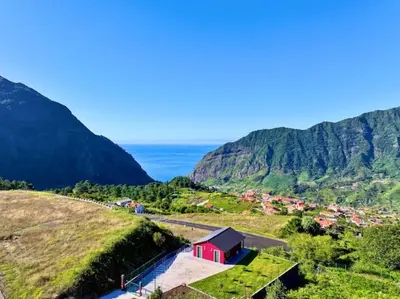 a small red house on a hill near the ocean at Ginjas Mountain Houses in São Vicente