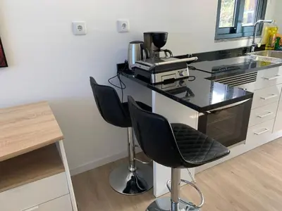 a kitchen with two bar stools and a counter with a coffee maker at Ginjas Mountain Houses in São Vicente