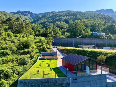 a small red house with a yard with grass at Ginjas Mountain Houses in São Vicente