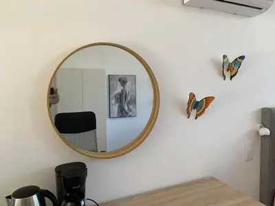 a mirror hanging on a white wall with a table at Ginjas Mountain Houses in São Vicente