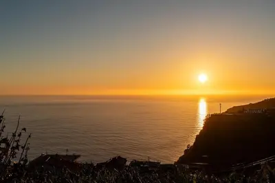 a sunset over the ocean with the sun setting at Sunset House in Calheta