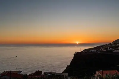 a sunset over the ocean with the sun setting at Sunset House in Calheta