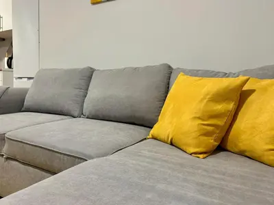 a gray couch with two yellow pillows on it at Casa do Perestrelo - Guest House in Machico