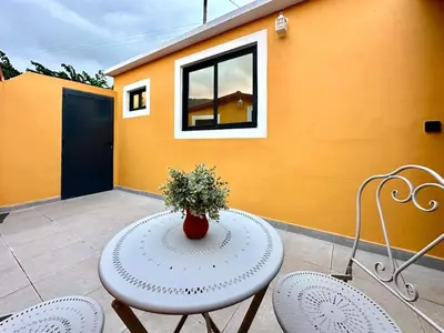 a table and two chairs with a vase on it at Casa do Perestrelo - Guest House in Machico
