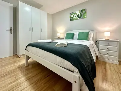 a bedroom with a large bed with green pillows at Casa do Perestrelo - Guest House in Machico