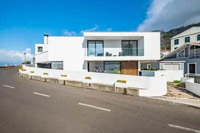 a white house on the side of a road at Porto Moniz Atlantic View in Porto Moniz