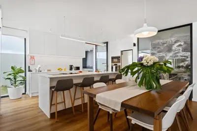 a kitchen and dining room with a wooden table and chairs at Porto Moniz Atlantic View in Porto Moniz