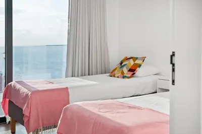 a bedroom with two beds and a large window at Porto Moniz Atlantic View in Porto Moniz