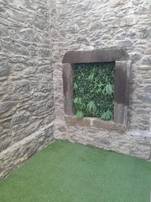 a stone wall with a window with plants in it at Ferreiros 184 in Funchal