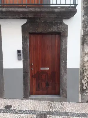 a wooden door with graffiti on it on a building at Ferreiros 184 in Funchal
